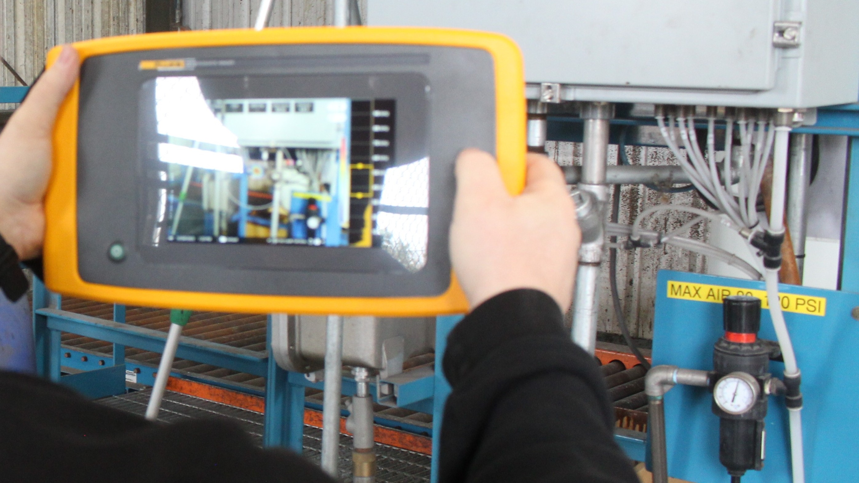Technician using acoustic imaging to locate compressed air leaks